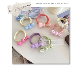 Close-up of colorful macaron bow elastic hair ties in six pastel colors on a table