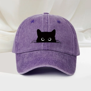Détail de la casquette de baseball violette lavée avec silhouette de chat noir et yeux blancs