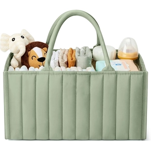 Quilted green baby diaper caddy with handles organized with toys and baby essentials