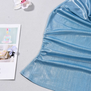 Detail of metallic blue ruched fabric showing fine pleated texture and glossy finish