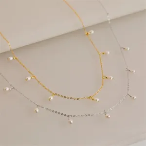 Detail of elegant gold and silver titanium necklaces with layered small pearls