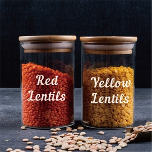 Detail of clear glass food jars with bamboo lids and white text for red and yellow lentils