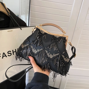 Detail of black sequin tassel evening bag with elegant gold metal frame and handle
