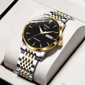 Macro shot of silver and gold stainless steel watch band with black dial details