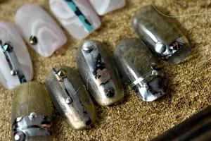 Macro view of Japanese nail stickers featuring marble texture and metallic 3D accents