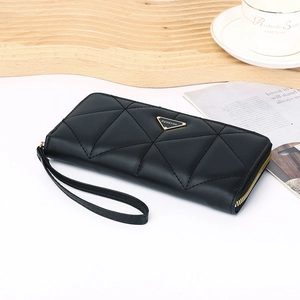 Close-up of black quilted leather wallet with gold zipper and fashion metal hardware