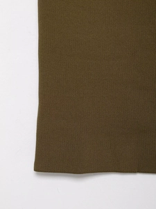 Gros plan du tissu en maille vert olive montrant la texture du tissage haute densité