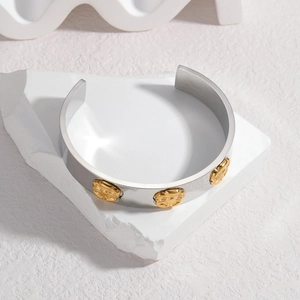 Minimalist C-shaped stainless steel cuff bracelet with three golden flower relief accents