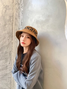 Détail d'un chapeau bob en coton marron avec broderie DGING porté par un mannequin