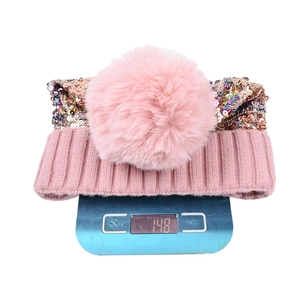 Berretto in maglia rosa con paillettes che pesa 148g su una bilancia digitale di precisione
