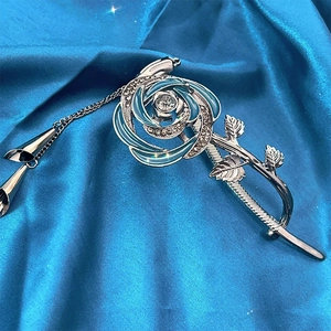 Détail de la pince à cheveux rose argentée avec émail bleu, strass et glands longs