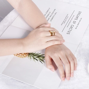 Close-up of a gold Roman numeral titanium ring worn elegantly on a model finger
