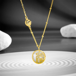 Vue détaillée du collier en titane doré avec pendentif Fu et incrustation de nacre