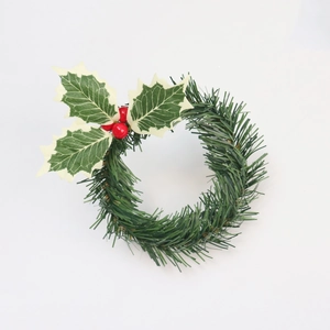 Detail of Christmas candle ring with green pine needles, holly leaves and red berries