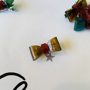 Fermaglio per capelli a fiocco traslucido rosso e ambra con logo France dorato