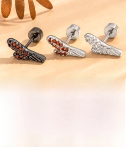 Macro detail of dragon horn ear studs in titanium steel with cubic zirconia inlay