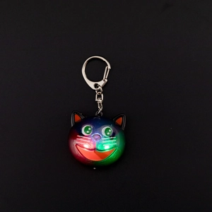 Macro detail of cute tricolor cat pendant with gradient resin and silver keychain ring