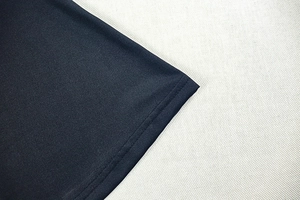 Close-up of double-stitch sewing on dark blue patchwork bodycon dress fabric
