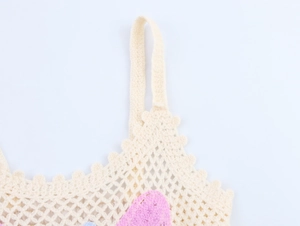 Close-up of beige crochet top strap with hollow knit texture and scalloped edges