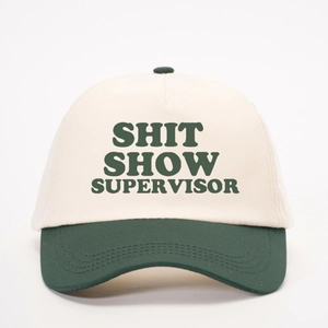 Two-tone baseball cap in beige and green featuring SHIT SHOW SUPERVISOR print