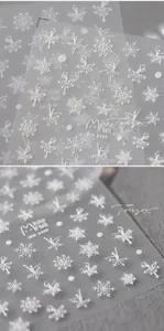 Macro detail of 5D white embossed nail stickers with snowflake and ballerina silhouette