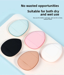 Detailed view of teardrop mini finger powder puffs in five colors on a wood surface