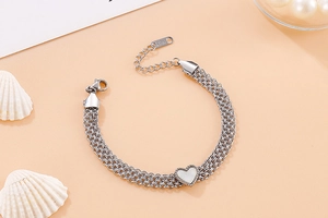 Detail of silver multi-layer stainless steel heart bracelet with lobster clasp and shell inlay