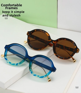 Detail of retro round sunglasses showing tortoiseshell frames and metallic temples
