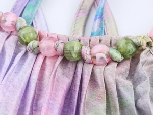 Détail du haut licou Y2K coloré montrant le tissu tie-dye avec plis et perles décoratives