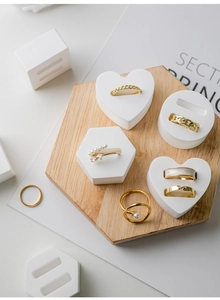 Macro shot of assorted gold rings with pearls and zircons on white display stands