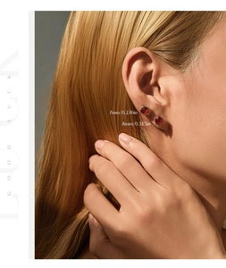 Close-up of 7mm and 8mm pomegranate red stud earrings shown on model ear