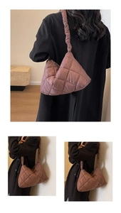 Detail of grey-pink quilted puffer bag showing the plush nylon texture and stitch patterns