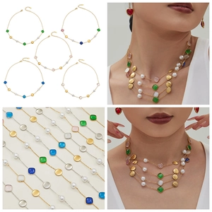 Close-up of 18k gold plated necklaces with colorful cat eye stones and pearls