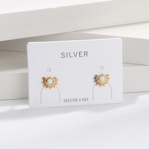 Detailed view of s925 silver sunburst stud earrings with white opal stone on display card