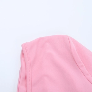 Détail de la texture du tissu en maille rose et qualité de couture professionnelle à l'épaule