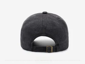 Detail view of adjustable bronze metal buckle on dark grey washed cotton baseball cap