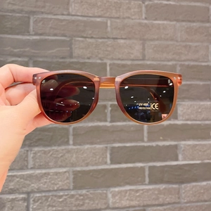 Detail of vintage reddish-brown kids sunglasses with UV400 grey lenses and CE mark