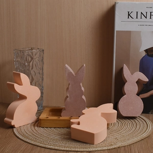 Detail view of rabbit silicone molds showing matte pink bunnies on a rustic wooden tray