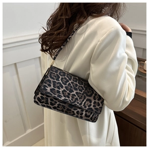 Detailed view of leopard print shoulder bag worn by model in white blazer