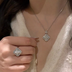 Elegant silver four-leaf clover necklace and ring set with pearls and zircons on a model