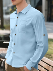 Detail of light blue linen shirt featuring a chest pocket and wood texture buttons