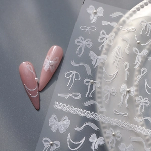 3D white embossed ribbon bow nail art stickers with pearls and lace on pink nails