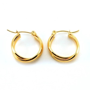 Detail of gold double-layered C-shape hoop earrings with a twisted metallic finish