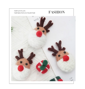 Macro view of handmade Christmas reindeer felt ornaments on white knit background
