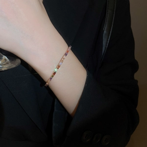 Detailed shot of a rose gold bracelet featuring colorful rectangular cut gemstones