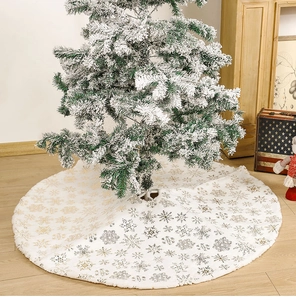 Close-up of white plush Christmas tree skirt with gold and silver snowflake patterns