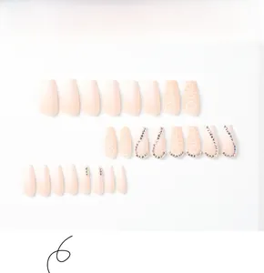 Detailed view of pink gradient matte press-on nails with rhinestones and heart patterns