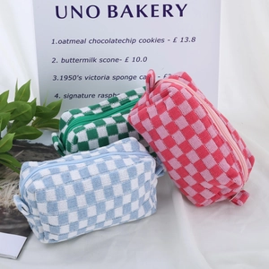 Drei farbenfrohe gestrickte Kosmetiktaschen mit Karomuster in Pink Blau und Grün
