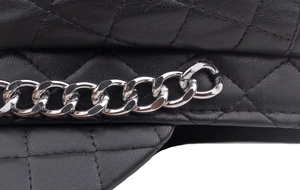 Close-up of black quilted leather military cap with a shiny silver metal chain accessory