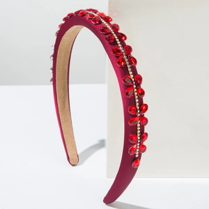Detailed view of red satin headband featuring sparkling rhinestone flower embellishments